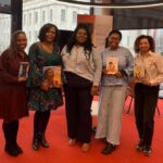 Authors holding their books during a visit to library