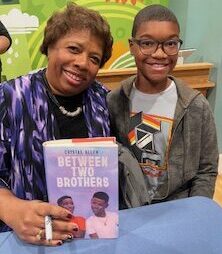 Author and child smiling as author holds a book