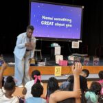 Author in front of screen talking to young readers